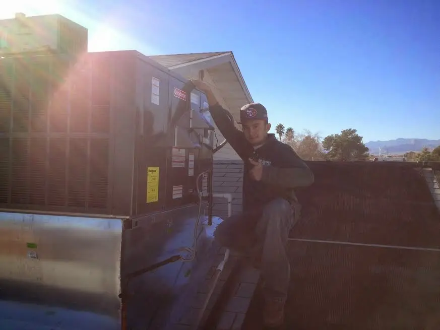 HVAC technician performing AC Tune-Up on a rooftop unit in Nutley